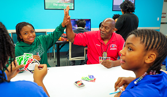 Teens playing UNO with a Waco Police Officer.